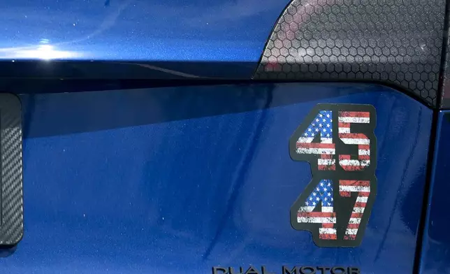 A Tesla vechile is seen near a charging station, Wednesday, March 19, 2025, in Woodstock, Ga. (AP Photo/Mike Stewart)