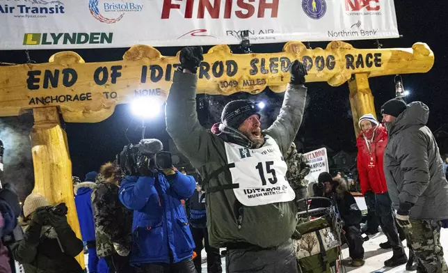 Jessie Holmes celebrates after winning the Iditarod Trail Sled Dog Race early Friday morning, March 14, 2025 in Nome. (Loren Holme/Anchorage Daily News via AP)