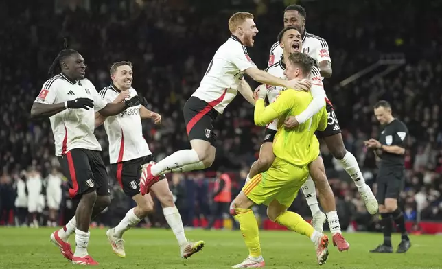 Fulham players celebrate after defeating Manchester United in a penalty shootout during the English FA Cup soccer match at the Old Trafford stadium in Manchester, England, Sunday, March 2, 2025. (AP Photo/Jon Super)