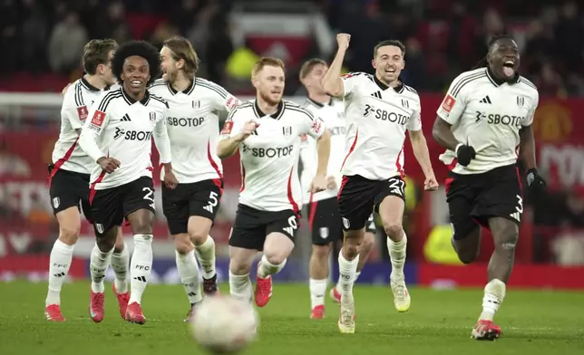 Fulham players celebrate after defeating Manchester United in a penalty shootout during the English FA Cup soccer match at the Old Trafford stadium in Manchester, England, Sunday, March 2, 2025. (AP Photo/Jon Super)