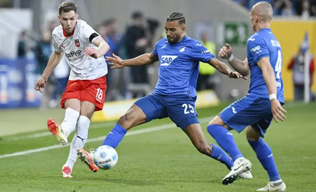 Heidenheim's Marvin Pieringer, left, in action with Hoffenheim's Kevin Akpoguma and Leo Ostigard, right, during the Bundesliga soccer match between TSG 1899 Hoffenheim and 1. FC Heidenheim at PreZero Arena, Sinsheim, Germany, Sunday March 9, 2025. (Uwe Anspach/dpavia AP)