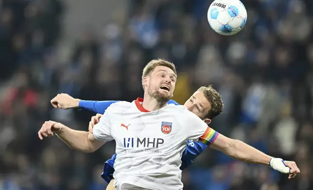 Heidenheim's Patrick Mainka, front, and Hoffenheim's Arthur Chaves in action during the Bundesliga soccer match between TSG 1899 Hoffenheim and 1. FC Heidenheim at PreZero Arena, Sinsheim, Germany, Sunday March 9, 2025. (Uwe Anspach/dpavia AP)