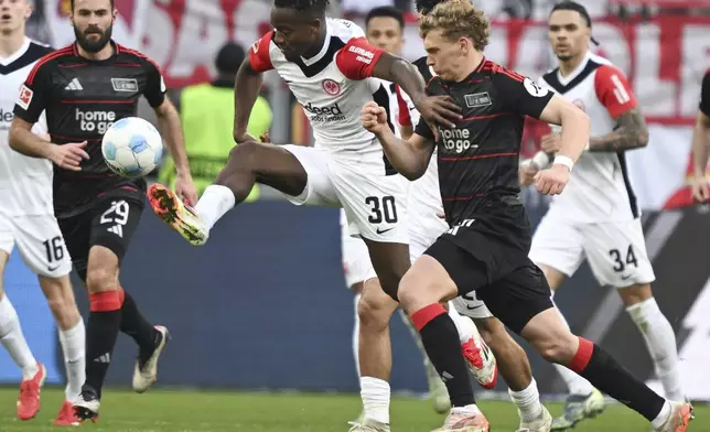 Frankfurt's Michy Batshuayi, center and Leopold Querfeld of Union Berlin vie for the ball, during the German Bundesliga soccer match between Eintracht Frankfurt and 1. FC Union Berlin at Deutsche Bank Park, in Frankfurt, Germany, Sunday, March 9, 2025. (Arne Dedert/dpa via AP)