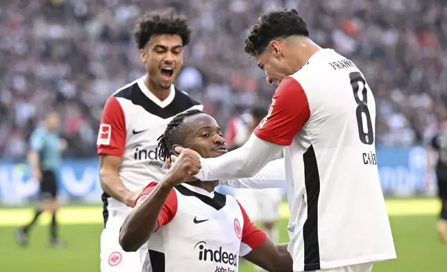 Frankfurt's Michy Batshuayi, center, celebrates with teammates Far's Chaibi, right and Nathaniel Brown after scoring a goal, during the German Bundesliga soccer match between Eintracht Frankfurt and 1. FC Union Berlin at Deutsche Bank Park, in Frankfurt, Germany, Sunday, March 9, 2025. (Arne Dedert/dpa via AP)