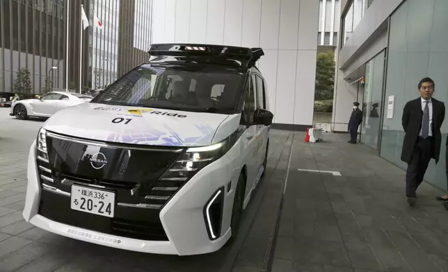 Nissan’s self-driving car moves from a road into the headquarters entrance way in a demonstration for reporters in Yokohama, near Tokyo, on March 6, 2025. (AP Photo/Yuri Kageyama)