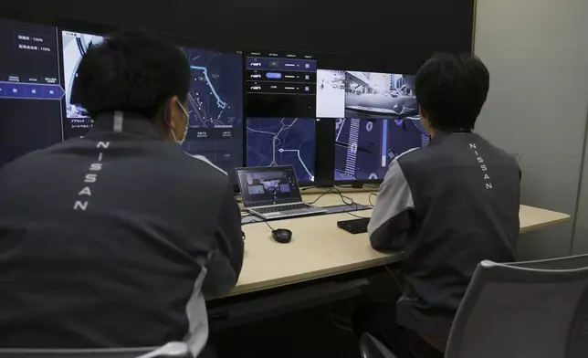 Nissan officials remotely monitor on screens the path and surroundings of the self-driving vehicle being tested on regular roads, so they can step in if problems happen, at Nissan headquarters in Yokohama, near Tokyo on March 6, 2025. (AP Photo/Yuri Kageyama)