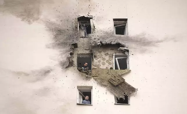 Investigators look at the damage of an apartment building where the downed Ukrainian drone fell in Sapronovo village outside Moscow, Russia, on Tuesday, March 11, 2025. (AP Photo)