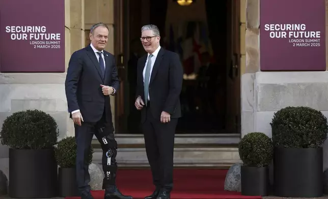 Britain's Prime Minister Keir Starmer, right, welcomes Poland Prime Minister Donald Tusk to the European leaders' summit to discuss Ukraine, at Lancaster House, London, Sunday March 2, 2025. (Toby Melville/Pool via AP)