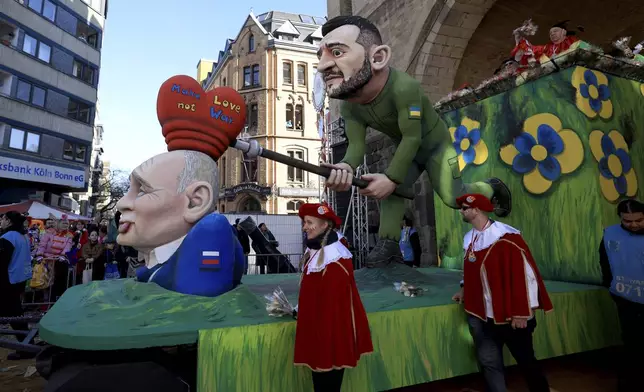 A carnival float despicts Ukrainian President Volodymyr Zelenskyy and Russia's President Vladimir Putin during the traditional Rose Monday carnival parade in Cologne, Germany, Monday, March 3, 2025. (Oliver Berg/dpa via AP)