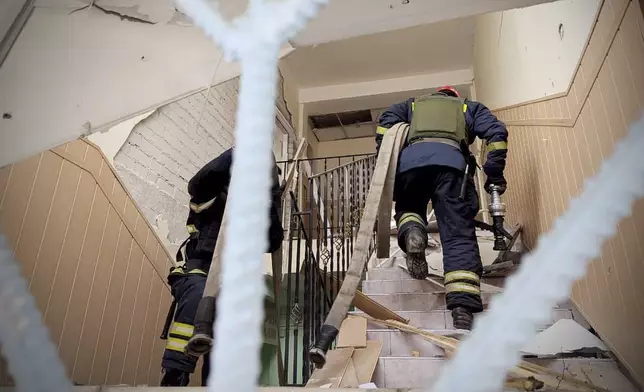 In this photo provided by the Ukrainian Emergency Service, firefighters work on the site of a damaged building after a Russian missile hit the area, in Kryvyi Rih, Ukraine, Wednesday, March 12, 2025. (Ukrainian Emergency Service via AP)