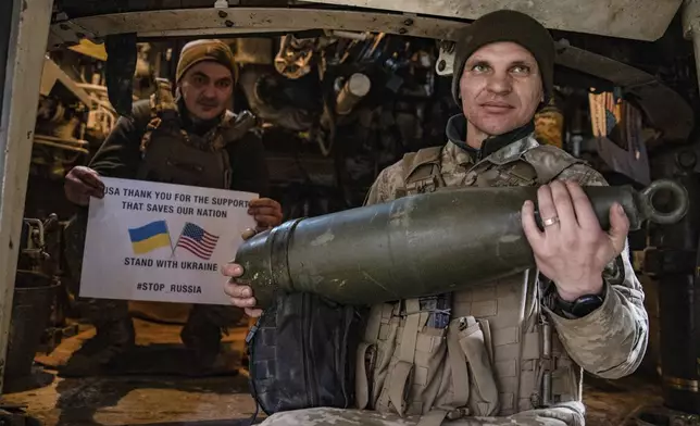 Soldiers of Ukraine's 5th brigade hold a poster thanking for the US for support during a flashmob at the front line near Toretsk, Donetsk region, Ukraine, Tuesday, March 11, 2025. (AP Photo/Roman Chop)