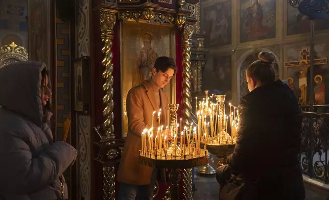 People light candles as they pray for peace in St.Michael Cathedral in Kyiv, Ukraine, Sunday, March 2, 2025. (AP Photo/Efrem Lukatsky)