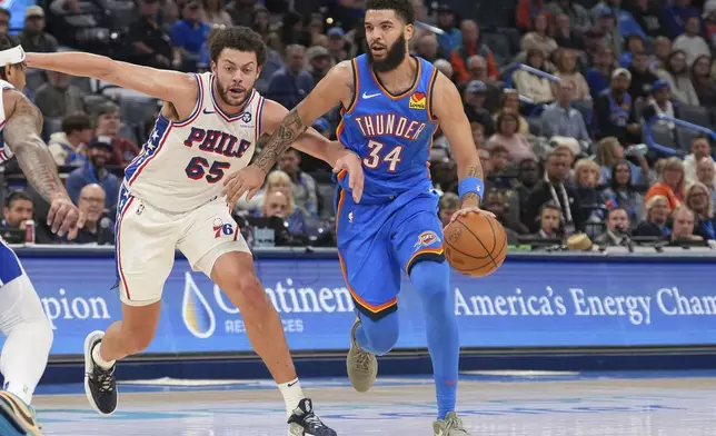 Oklahoma City Thunder forward Kenrich Williams (34) pushes past Philadelphia 76ers forward Alex Reese during the second half of an NBA basketball game, Wednesday, March 19, 2025, in Oklahoma City. (AP Photo/Kyle Phillips)
