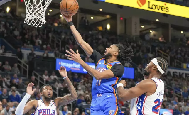 Oklahoma City Thunder guard Isaiah Joe, middle, shoots near Philadelphia 76ers forward Justin Edwards, left, and Guerschon Yabusele, right, during the second half of an NBA basketball game, Wednesday, March 19, 2025, in Oklahoma City. (AP Photo/Kyle Phillips)