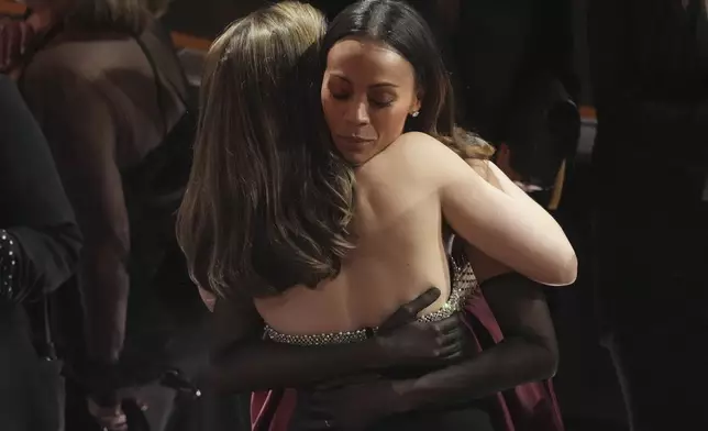 Ana de Armas, left, and Zoe Saldana embrace in the audience during the Oscars on Sunday, March 2, 2025, at the Dolby Theatre in Los Angeles. (AP Photo/Chris Pizzello)