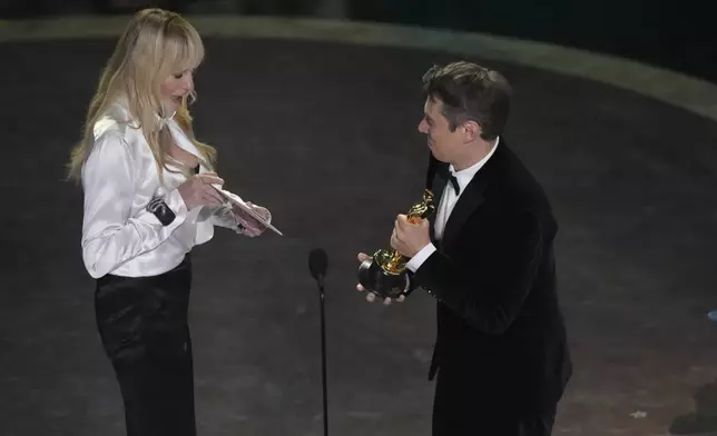 Daryl Hannah, left, presents the award for best film editing to Sean Baker for "Anora" during the Oscars on Sunday, March 2, 2025, at the Dolby Theatre in Los Angeles. (AP Photo/Chris Pizzello)