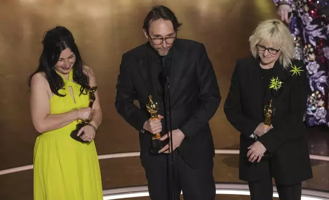 Marilyne Scarselli, from left, Pierre-Olivier Persin, and Stephanie Guillon accept the award for best makeup and hairstyling for "The Substance" during the Oscars on Sunday, March 2, 2025, at the Dolby Theatre in Los Angeles. (AP Photo/Chris Pizzello)