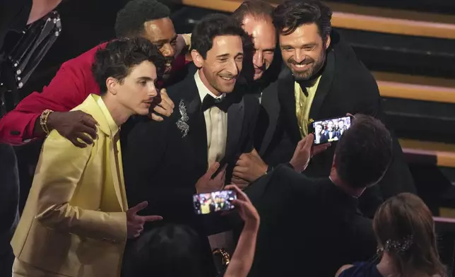 Timothee Chalamet, from left, Colman Domingo, Adrien Brody, Ralph Fiennes, and Sebastian Stan pose in the audience during the Oscars on Sunday, March 2, 2025, at the Dolby Theatre in Los Angeles. (AP Photo/Chris Pizzello)