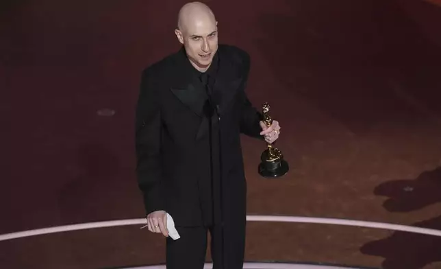 Daniel Blumberg accepts the award for best original score for "The Brutalist" during the Oscars on Sunday, March 2, 2025, at the Dolby Theatre in Los Angeles. (AP Photo/Chris Pizzello)