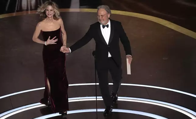 Meg Ryan, left, and Billy Crystal presents the award for best picture during the Oscars on Sunday, March 2, 2025, at the Dolby Theatre in Los Angeles. (AP Photo/Chris Pizzello)