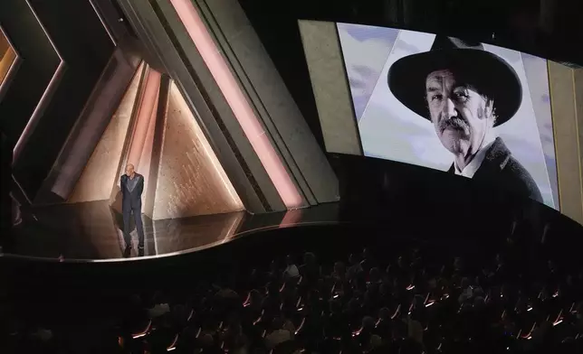 Morgan Freeman speaks about Gene Hackman with an image of Gene Hackman on the screen during the Oscars on Sunday, March 2, 2025, at the Dolby Theatre in Los Angeles. (AP Photo/Chris Pizzello)