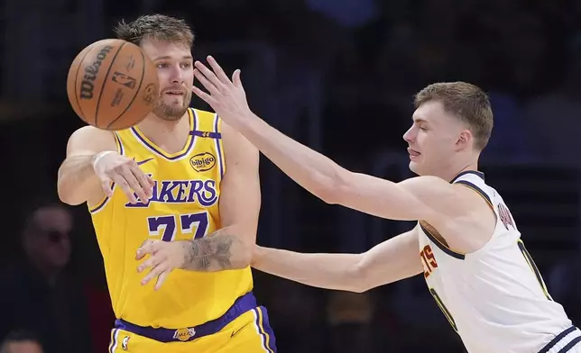 Los Angeles Lakers guard Luka Doncic, left, passes while under pressure from Denver Nuggets guard Christian Braun during the second half of an NBA basketball game Wednesday, March 19, 2025, in Los Angeles. (AP Photo/Mark J. Terrill)