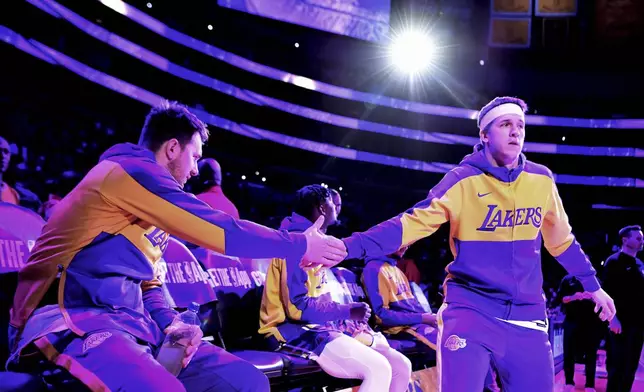 Los Angeles Lakers guard Luka Doncic, left, greets teammate Austin Reaves before an NBA basketball game with the Phoenix Suns, Sunday, March 16, 2025, in Los Angeles. (AP Photo/Wally Skalij)