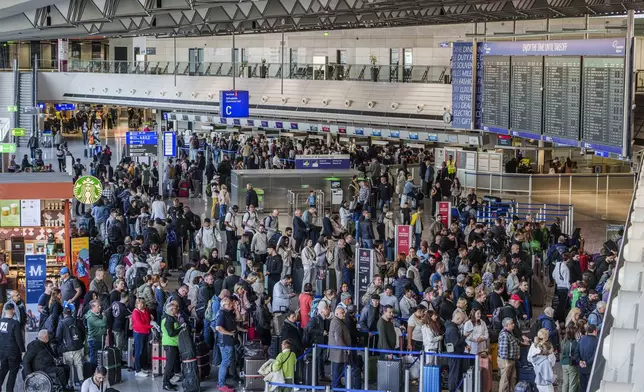 People queue in long lines in departure hall C at Rhine-Main Airport, Frankfurt, Germany, Sunday March 9, 2025, a day ahead of a planned strike across Germany amid new contract negotiations. (Andreas Arnold/dpa via AP)