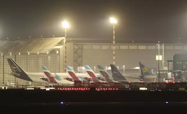 Aircraft are parked at the terminal building at D'sseldorf Airport, Germany early Monday, March 10, 2025. (Christoph Reichwein/dpa via AP)