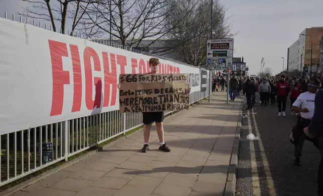 A Manchester United fan holds up a sign with concerns to ticket pricing prior to the English Premier League soccer match between Manchester United and Arsenal at Old Trafford stadium in Manchester, England, Sunday, March 9, 2025. (AP Photo/Dave Thompson)