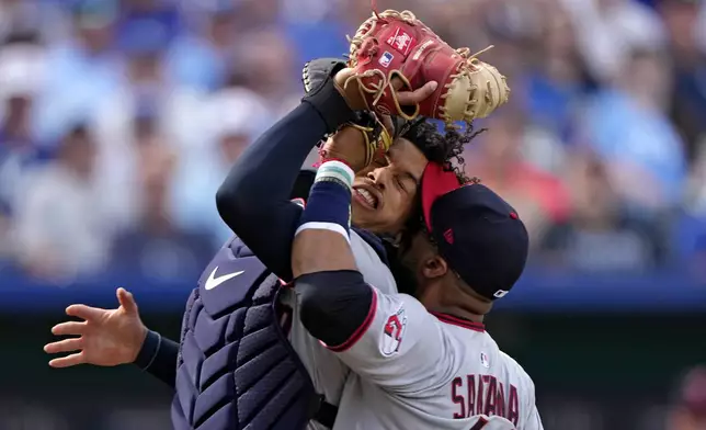 Cleveland Guardians catcher Bo Naylor and first baseman Carlos Santana collide after Naylor caught a fly foul ball for the out on Kansas City Royals' Jonathan India during the third inning of a baseball game Thursday, March 27, 2025, in Kansas City, Mo. (AP Photo/Charlie Riedel)