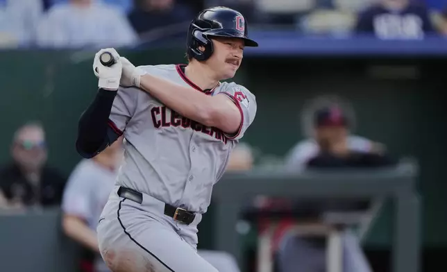 Cleveland Guardians' Kyle Manzardo watches his two-run double during the 10th inning of a baseball game against the Kansas City Royals Thursday, March 27, 2025, in Kansas City, Mo. (AP Photo/Charlie Riedel)
