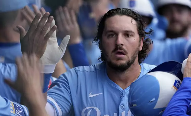 Kansas City Royals' Vinnie Pasquantino celebrates in the dugout after hitting a three-run home run during the third inning of a baseball game against the Cleveland Guardians Thursday, March 27, 2025, in Kansas City, Mo. (AP Photo/Charlie Riedel)