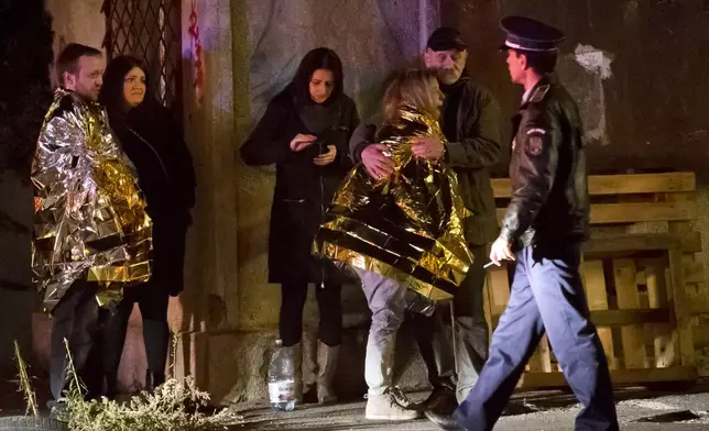 FILE - A survivor of a fire that occurred in a club in Bucharest, Romania, cries, wrapped in a thermal blanket outside the scene early Saturday, Oct. 31, 2015. (AP Photo/Vadim Ghirda, File)