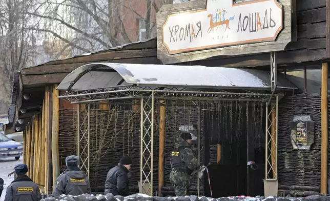 FILE - Police officers and investigators work at the Lame Horse nightclub where a fire broke out late Friday, in Perm, about 700 miles (1,200 kilometers) east of Moscow, Saturday, Dec. 5, 2009. (AP Photo/Misha Japaridze, File)