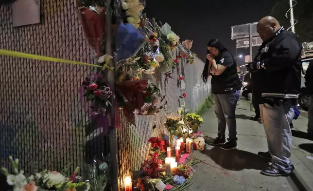 FILE - Sol Rodriguez, center, and Aaron Torres visit a shrine for the victims of a warehouse fire near the site Sunday, Dec. 4, 2016, in Oakland, Calif. (AP Photo/Marcio Jose Sanchez, File)