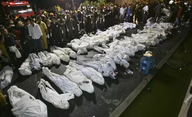 FILE - Fire and Rescue officials collect victims Thursday, Jan. 1, 2009, following a night club fire in Bangkok, Thailand. At least fifty people were killed when fire broke out during New Year's Eve celebrations at a popular Bangkok night club. (AP Photo/Sakchai Lalit, File)