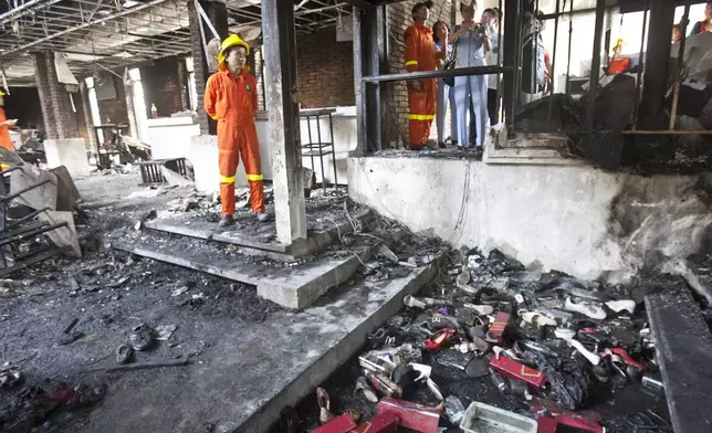 FILE - Fire and Rescue officials along with others inspect the Santika nightclub Thursday, Jan. 1, 2009, in Bangkok, Thailand. (AP Photo/David Longstreath, File)