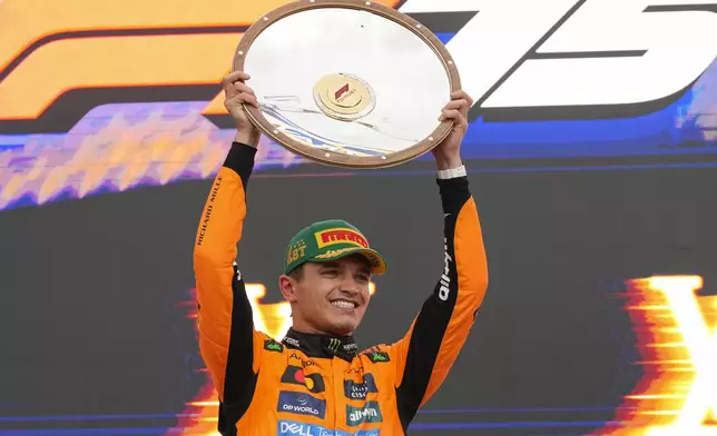 McLaren driver Lando Norris of Britain celebrates on the podium after winning the Australian Formula One Grand Prix at Albert Park, in Melbourne, Australia, Sunday, March 16, 2025. (AP Photo/Asanka Brendon Ratnayake)