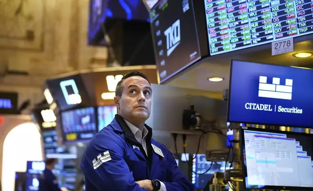 People work on the floor at the New York Stock Exchange in New York, Wednesday, March 19, 2025. (AP Photo/Seth Wenig)