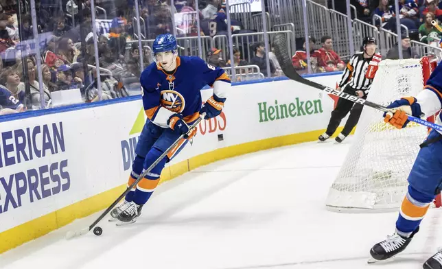 New York Islanders defenseman Noah Dobson (8) skates with the puck during the first period of an NHL hockey game against the Florida Panthers, Sunday, March 16, 2025, in Elmont, N.Y. (AP Photo/Stefan Jeremiah)