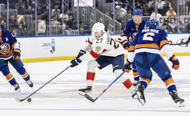 Florida Panthers center Eetu Loustarinen (27) controls the puck during the first period of an NHL hockey game against the New York Islanders, Sunday, March 16, 2025, in Elmont, N.Y. (AP Photo/Stefan Jeremiah)