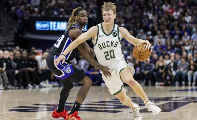Milwaukee Bucks guard AJ Green (20) drives to the basket past Sacramento Kings guard Keon Ellis, left, during the first half of an NBA basketball game Saturday, March 22, 2025, in Sacramento, Calif. (AP Photo/Sara Nevis)