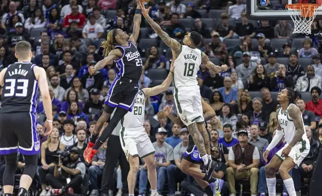Sacramento Kings guard Keon Ellis (23) jumps to grab the rebound from Milwaukee Bucks forward Kyle Kuzma (18) during the first half of an NBA basketball game Saturday, March 22, 2025, in Sacramento, Calif. (AP Photo/Sara Nevis)