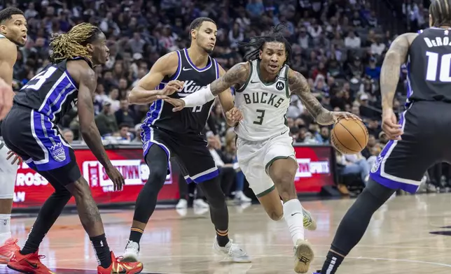 Milwaukee Bucks guard Kevin Porter Jr. (3) drives to the basket as Sacramento Kings forward Keegan Murray, center left, defends during the first half of an NBA basketball game Saturday, March 22, 2025, in Sacramento, Calif. (AP Photo/Sara Nevis)