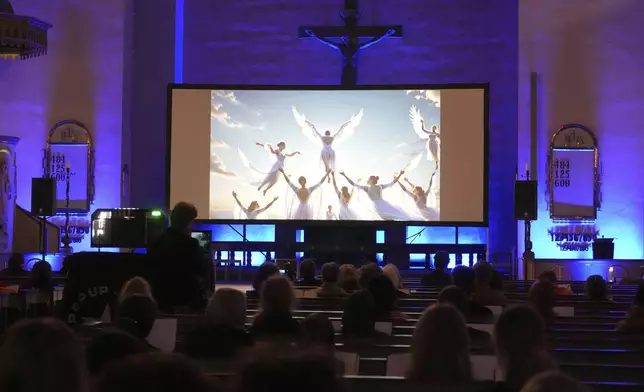 People watch an AI-created service at St. Paul's Lutheran church in Helsinki, Finland, Tuesday, March 4, 2025. (AP Photo/Sergei Grits)