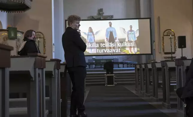 The Rev. Petja Kopperoinen and the Rev. Kari Kanala, left, talk to colleagues during a rehearsal for an AI-created service in St. Paul's Lutheran church in Helsinki, Finland, Tuesday, March 4, 2025. (AP Photo/Sergei Grits)