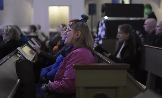 People sing as they attend an AI-created service at St. Paul's Lutheran church in Helsinki, Finland, Tuesday, March 4, 2025. (AP Photo/Sergei Grits)
