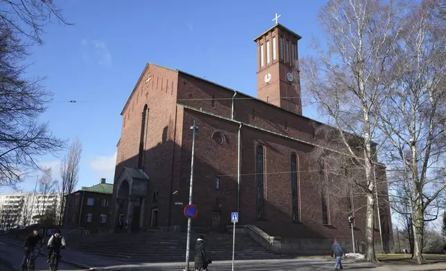 People pass by St. Paul's Lutheran church in Helsinki, Finland, Tuesday, March 4, 2025. (AP Photo/Sergei Grits)