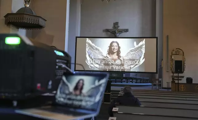 An AI-produced avatar seen on the screen during a rehearsal for an AI-created service in St. Paul's Lutheran church in Helsinki, Finland, Tuesday, March 4, 2025. (AP Photo/Sergei Grits)